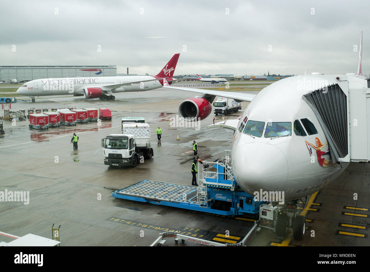 Virgin Atlantic Airbus A340 aircraft preparing for departure while a Virgin Boeing 787 passes in the background  at London Heathrow Airport Stock Photo