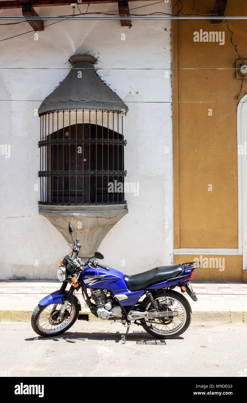 Motorbike parked in front of a colonial house with ornamental window in Granada, Nicaragua Stock Photo