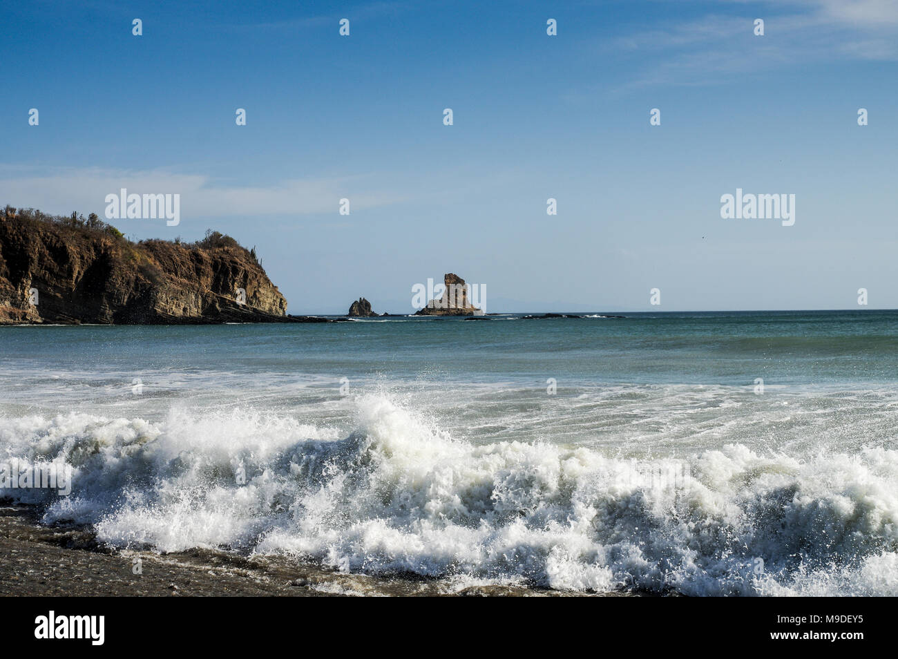 Beautiful Pacific Ocean crashing around the iconic rock formation on Playa Ocotal on west coast of Nicaragua Stock Photo