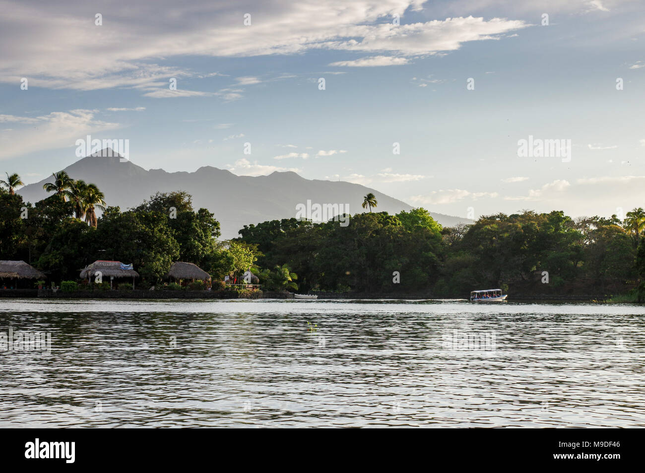 Boat passing through the Islets of Granada with Mombacho volcano in the background - Nicaragua, Central America Stock Photo