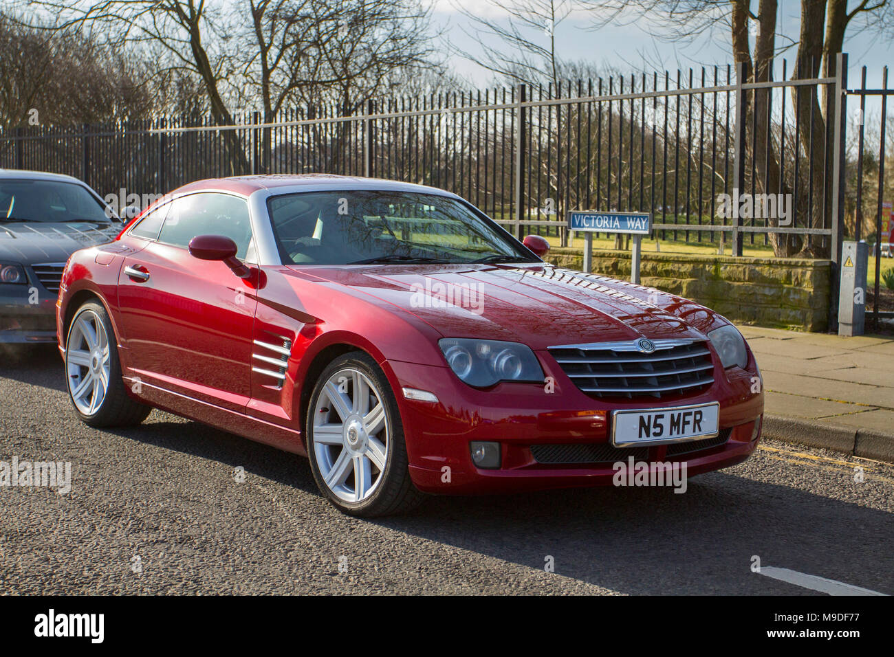 Supercars Southport, Merseyside, UK 25th March 2018.  UK Weather. 2004 red Chrysler Crossfire auto 3199cc petrol coupe at the North-West Supercar event as cars and tourists arrive in the coastal resort. Cars are bumper to bumper on the seafront esplanade as classic & American car enthusiasts take advantage of warm weather for a motoring day out. Stock Photo