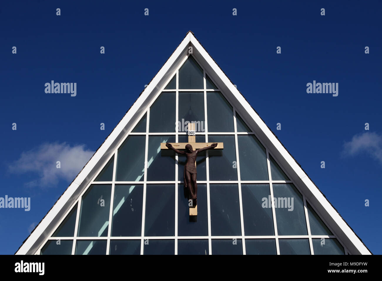 The crucifix on the front of St Margaret's RC church in Edinburgh set against a bright blue sky Stock Photo