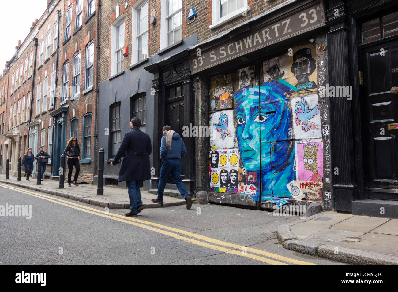 Street art on the gates to S. Schwartz at 33 Fournier Street, Spitalfields, London, E1, UK Stock Photo