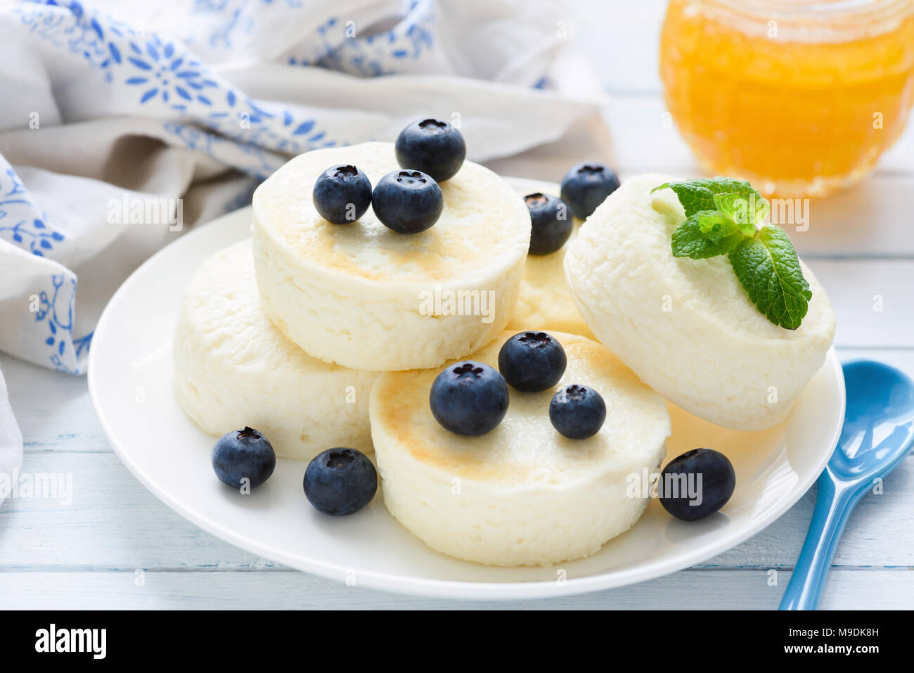 Syrniki, cottage cheese pancakes or cheesecakes with fresh berries and honey. Closeup view. Healthy breakfast, healthy dessert or snack Stock Photo