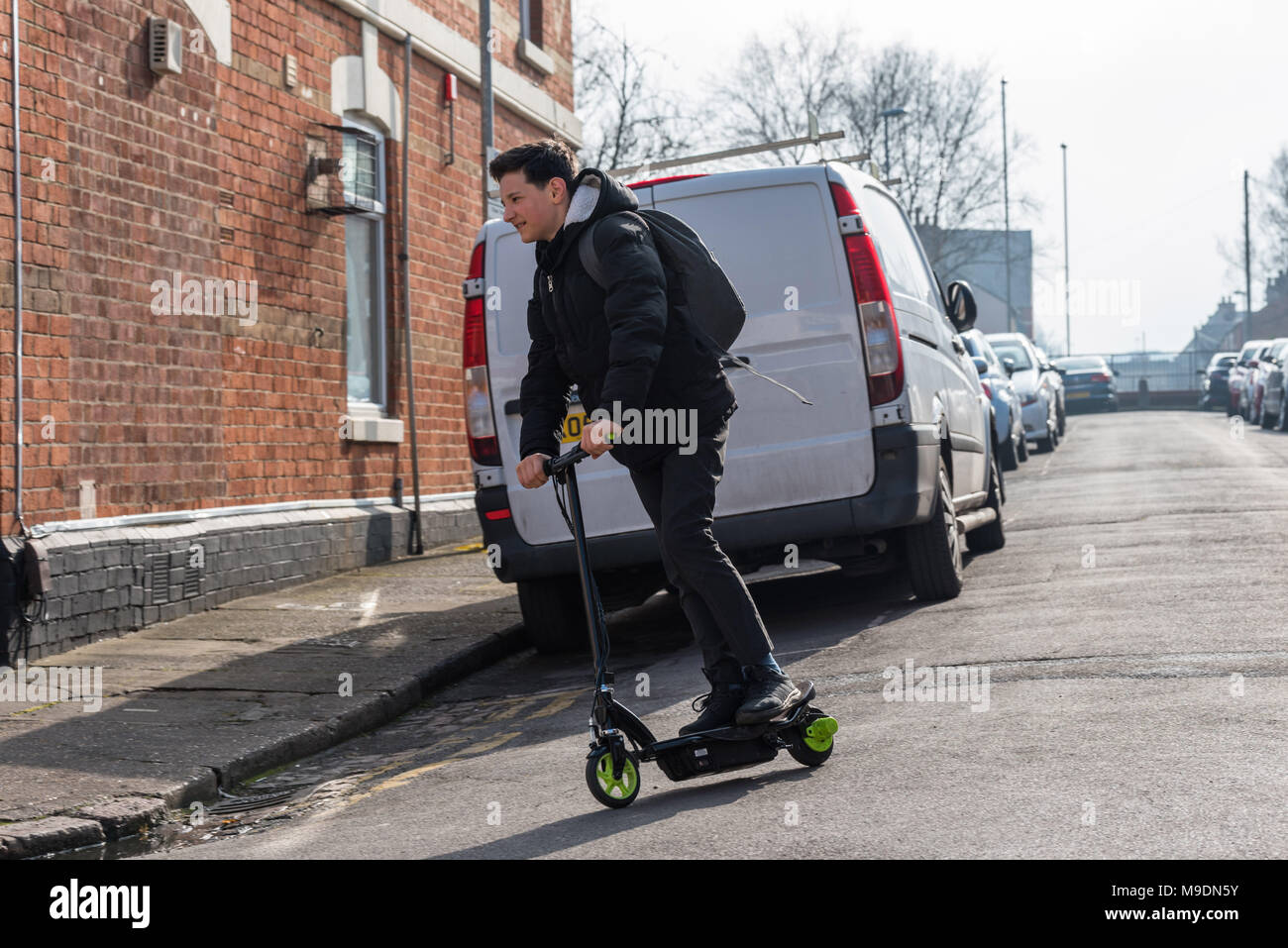 Boy on electrical scooter driving to British school in UK Stock Photo -  Alamy