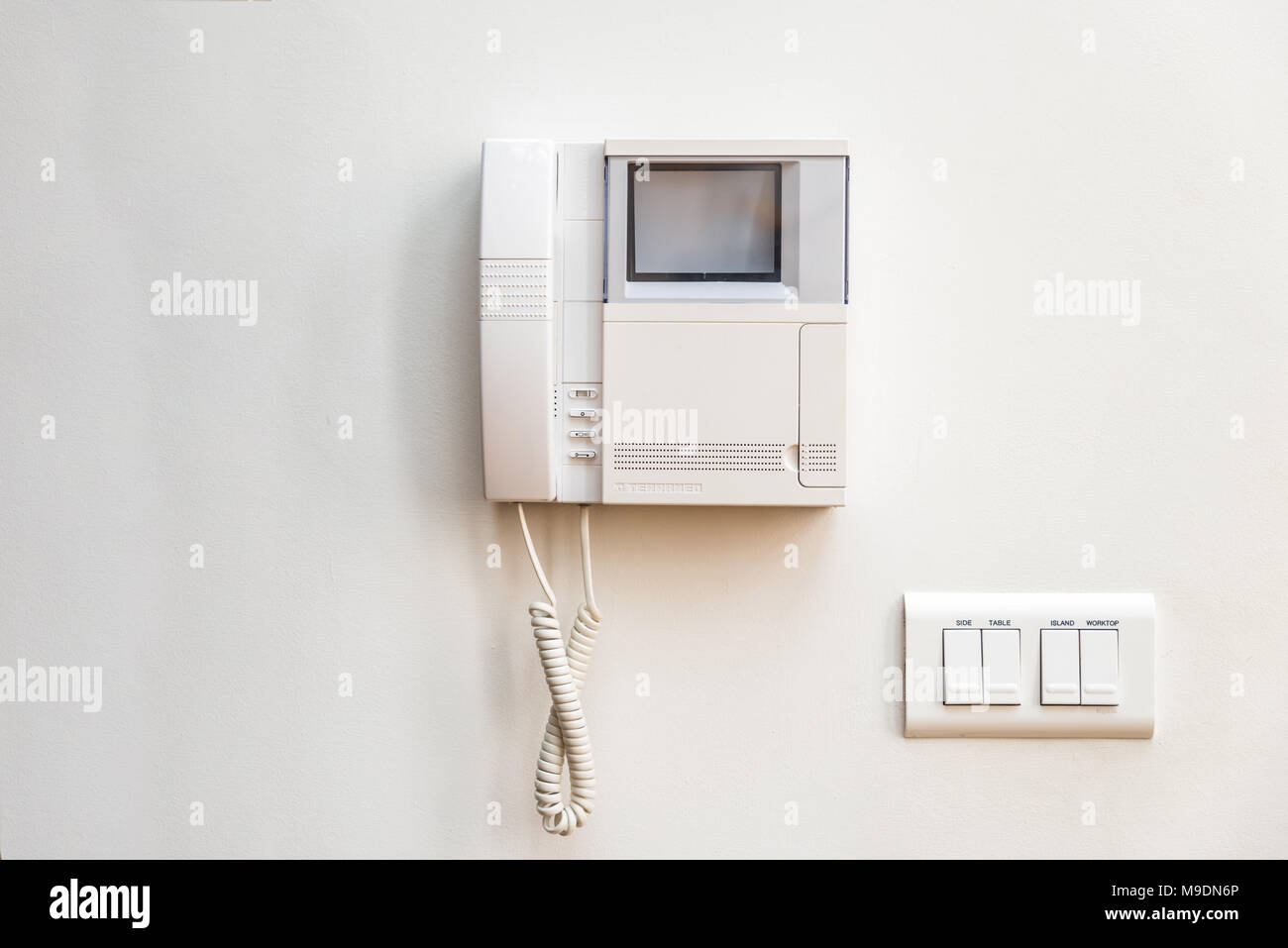 Closeup day view intercom unit on white wall in flat Stock Photo