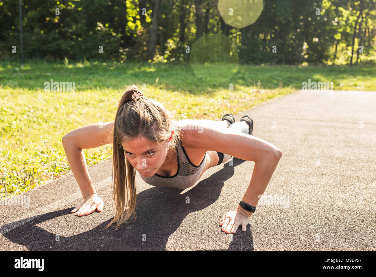 Fit woman doing push-ups at the park Stock Photo - Alamy