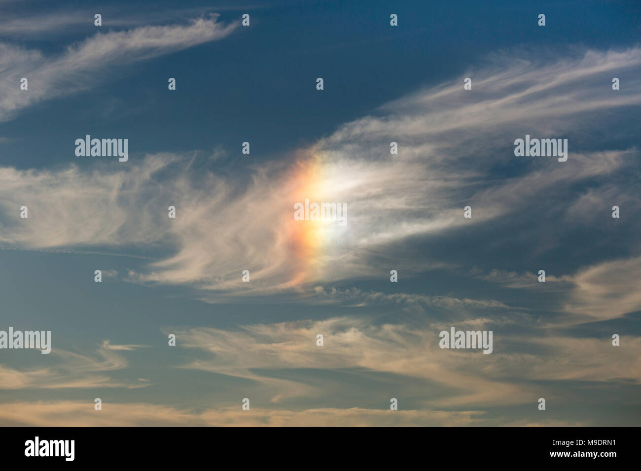 Parhelion or sun dog seen on the South Downs, Sussex, UK. These are sometimes known as a cloud rainbow. Stock Photo