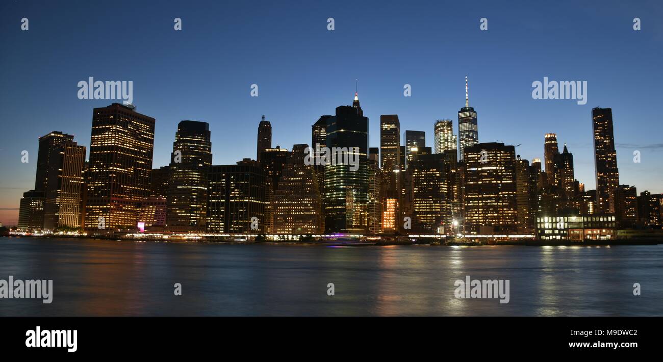 The skyline of downtown Manhattan, the Financial District, and Wall Street from Brooklyn at dusk. Stock Photo
