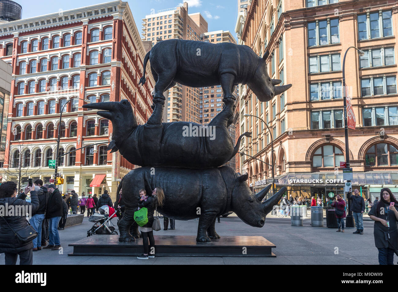 New York, NY, USA 24 March 2018 - New Yorkers flock to see a massive sculpture of three northern white rhinos in Astor Place entitled 'Goodbye Rhinos - The Last Three' It represents Sudan, Najin and Fatu.  the last living animals of a species that is now extinct in the wild. Stock Photo