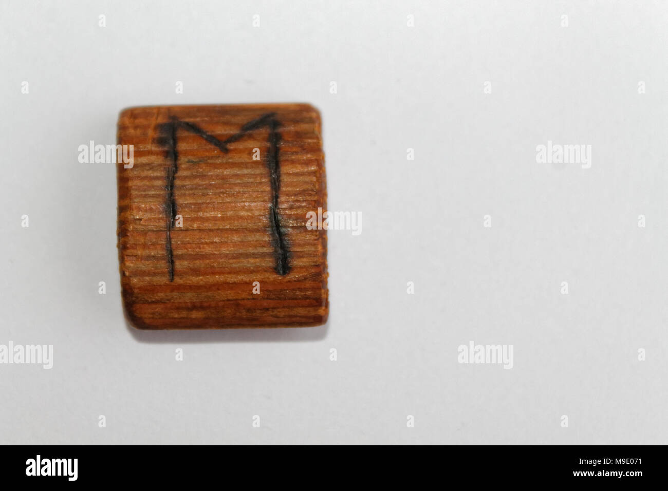 Wooden rune which means horse lie on a table on a white background ...