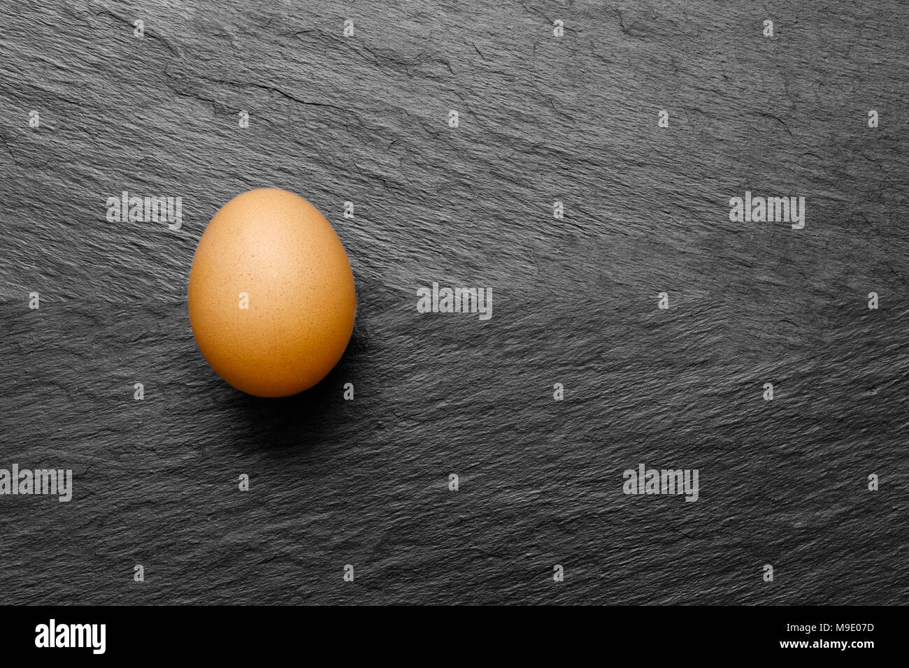 One chicken egg on black stone background surface with free space Stock ...