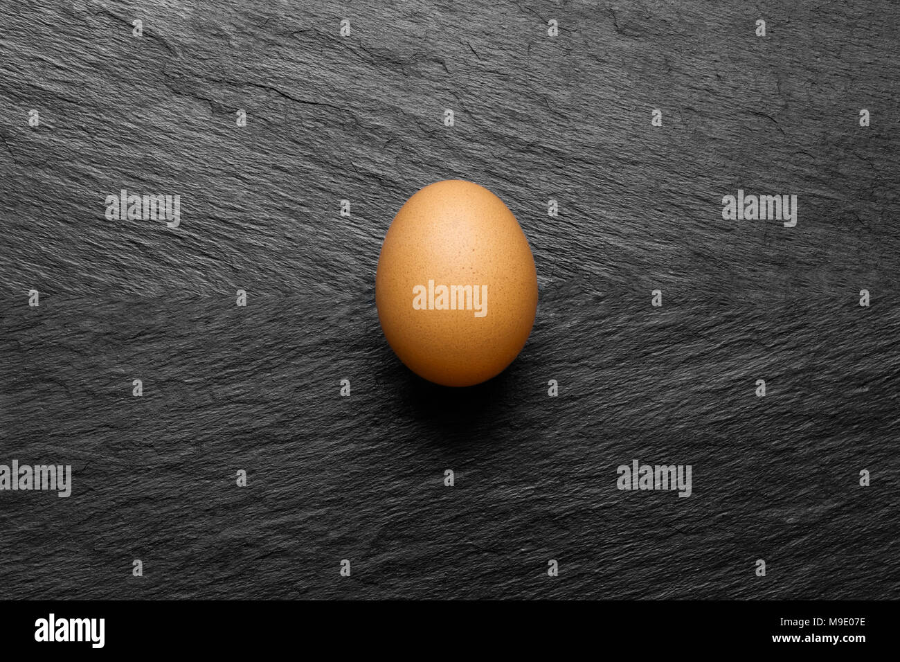 One chicken egg on black stone background surface with free space Stock ...