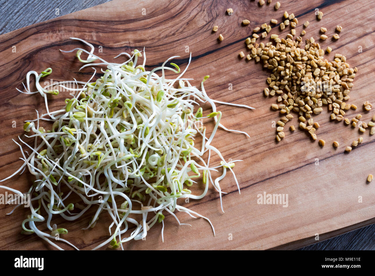 Sprouted and dry fenugreek seeds on a wooden table, top view Stock Photo