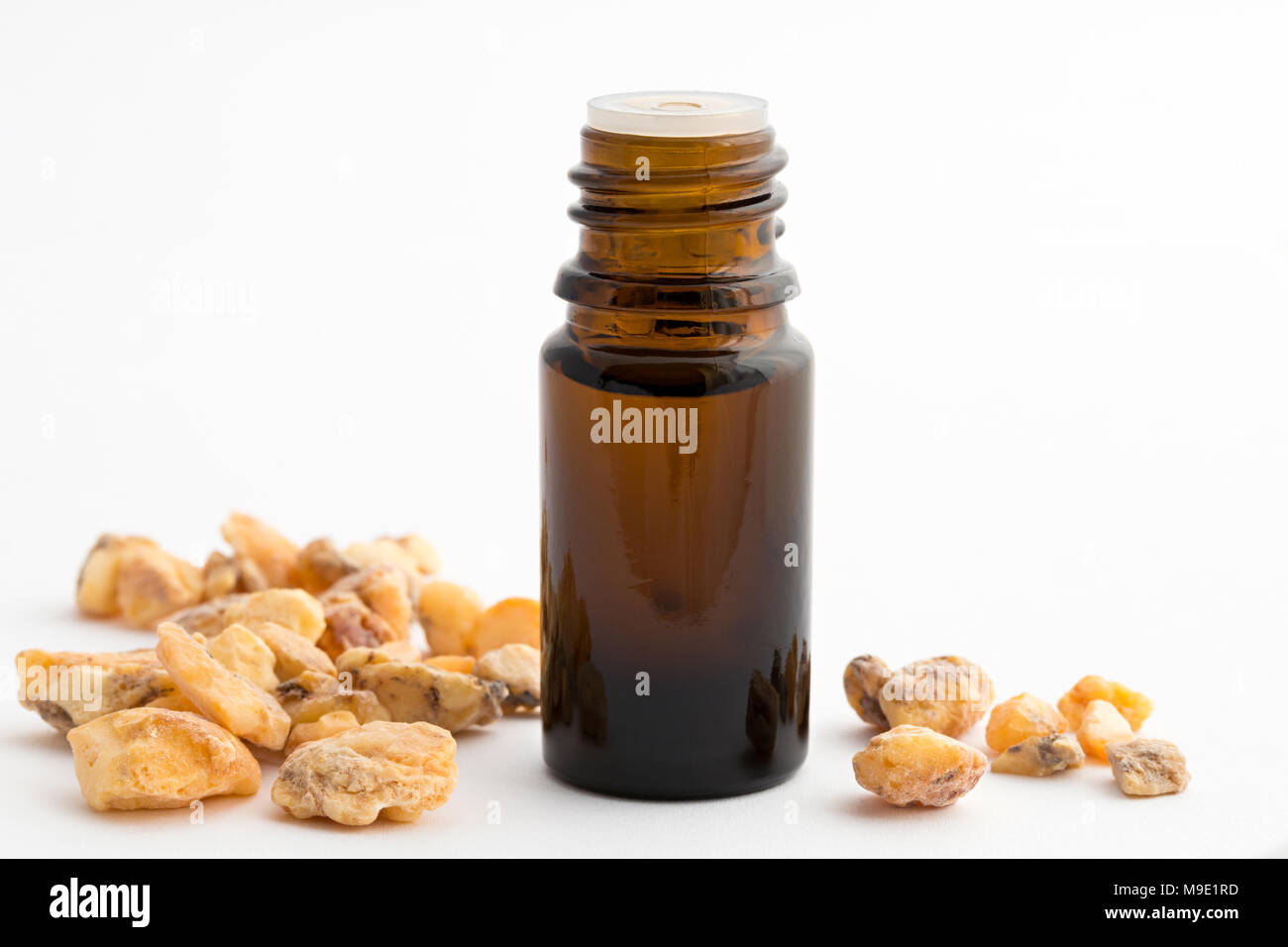 A bottle of styrax benzoin essential oil with styrax benzoin resin on a