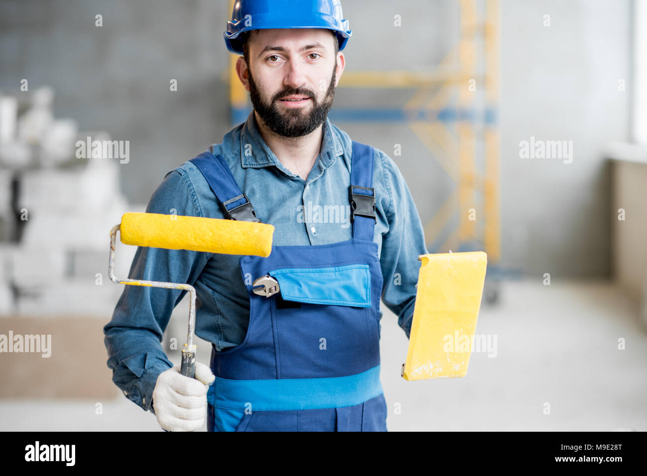 Builder with paint roll indoors Stock Photo Alamy