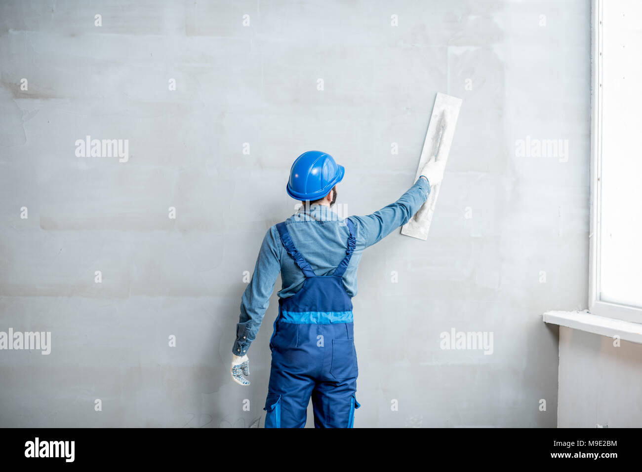 Plasterer working indoors Stock Photo