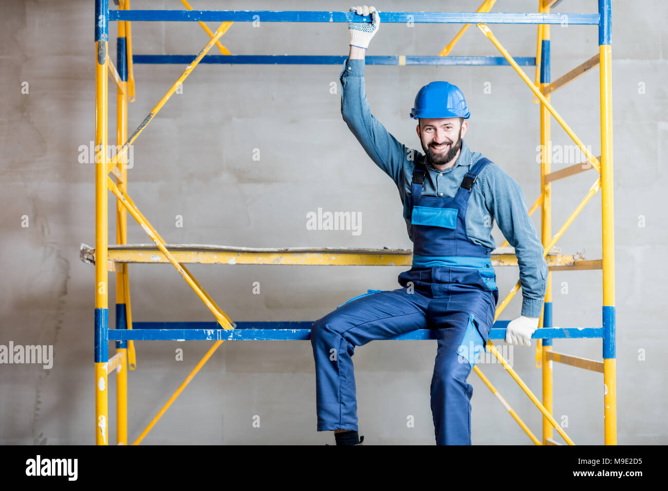 Builder on the scaffolding indoors Stock Photo