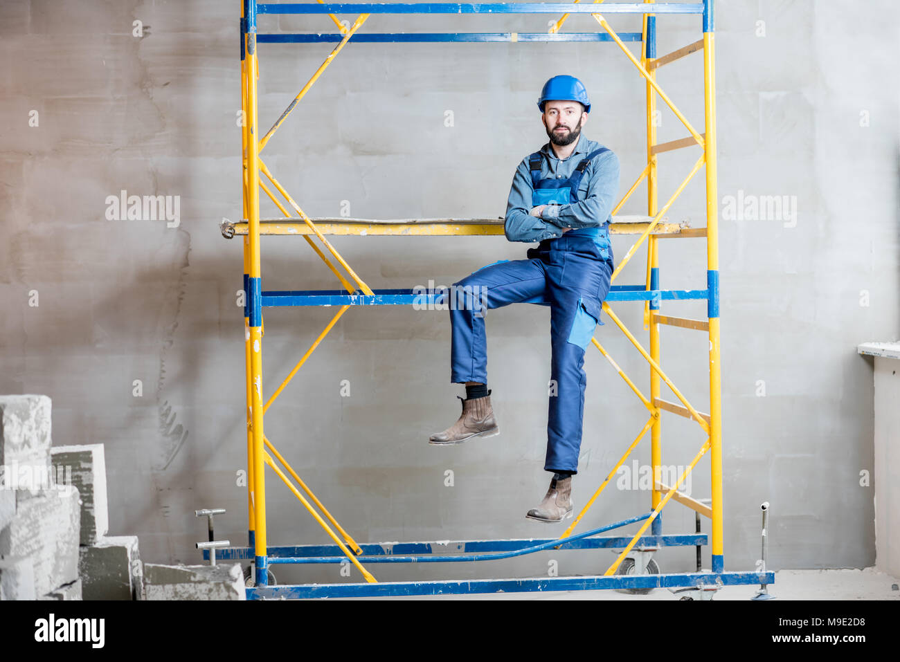 Builder on the scaffolding indoors Stock Photo
