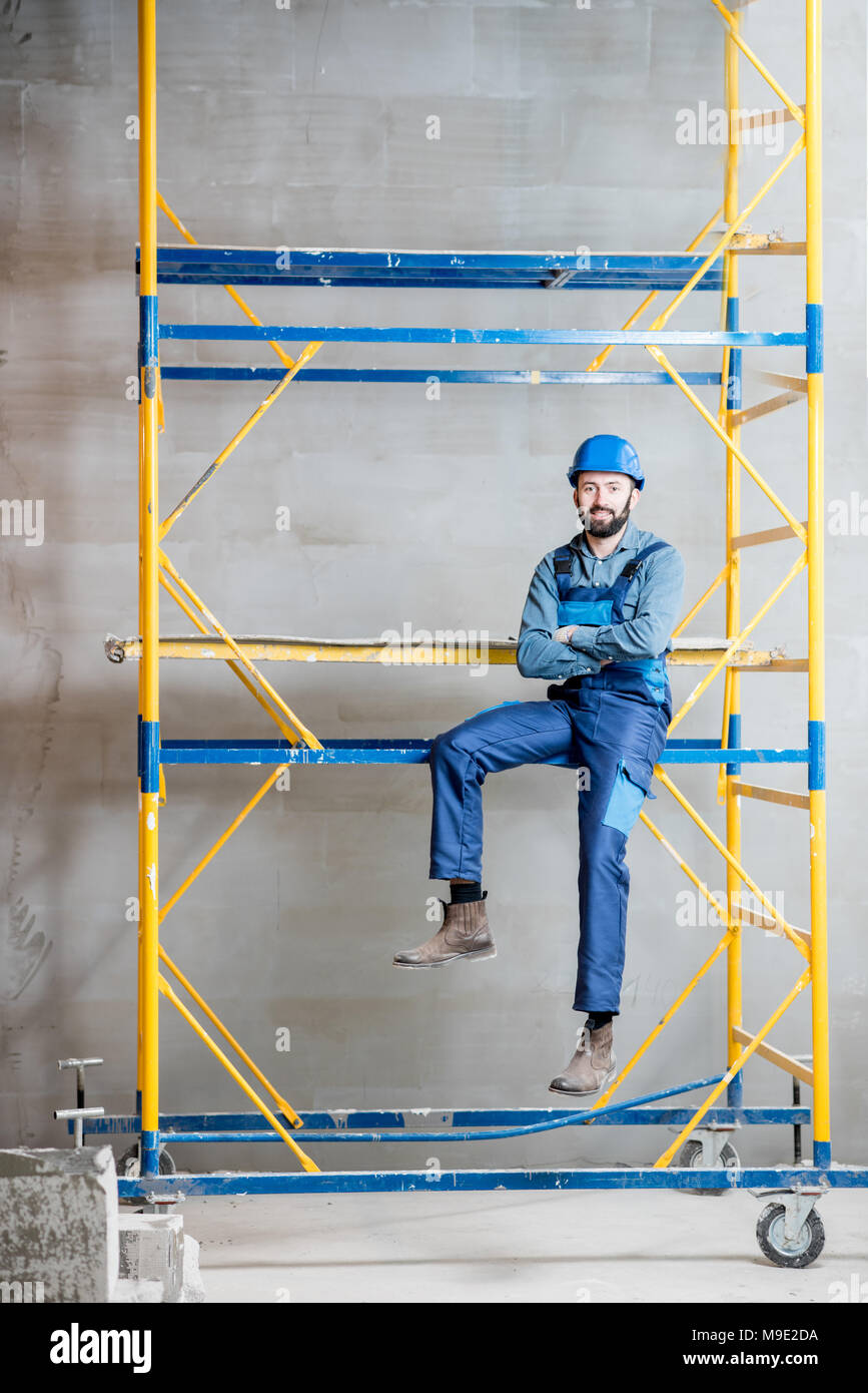 Builder on the scaffolding indoors Stock Photo