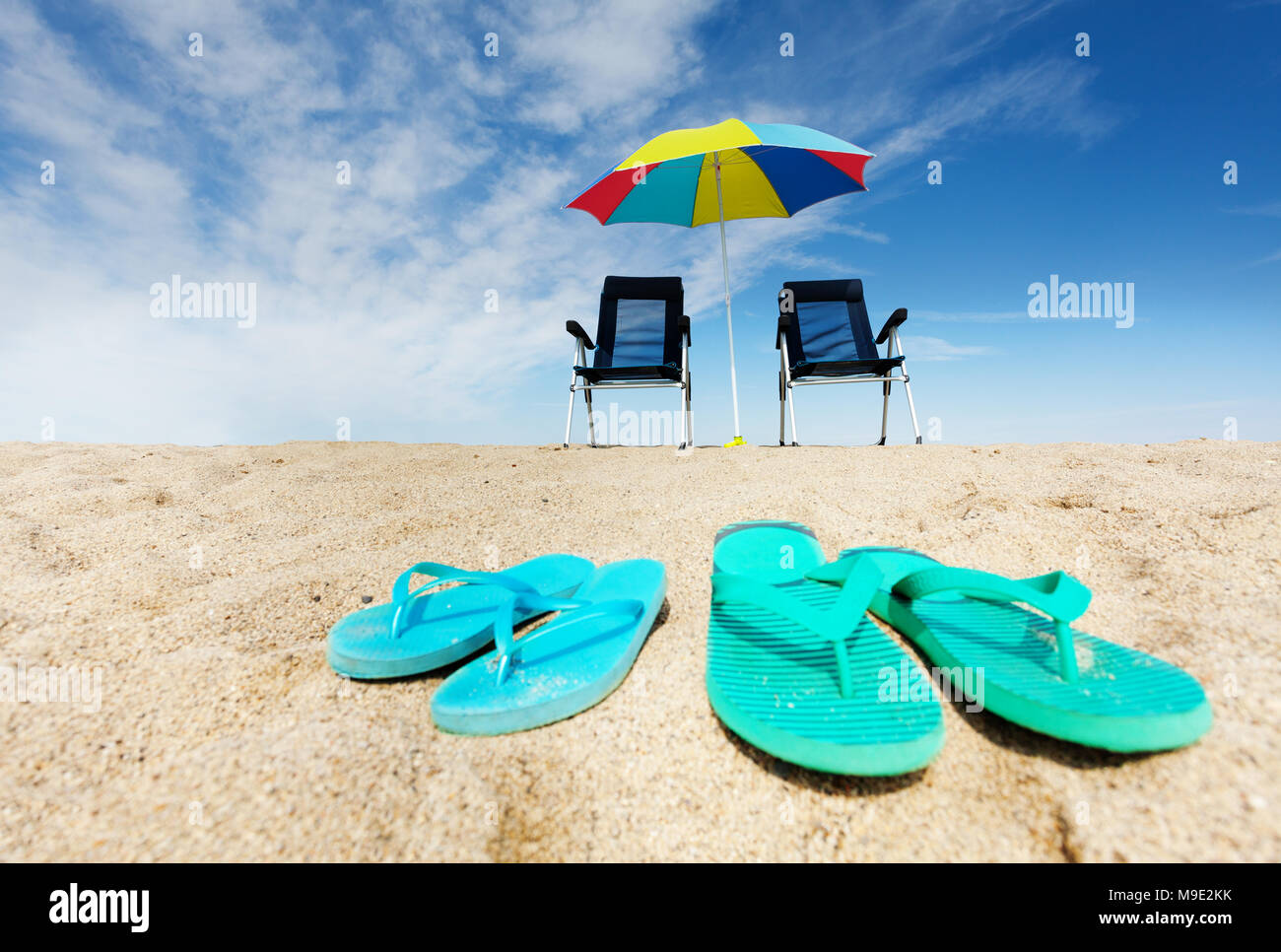 Flip flops, deck chairs and sun umbrella on beach Stock Photo - Alamy
