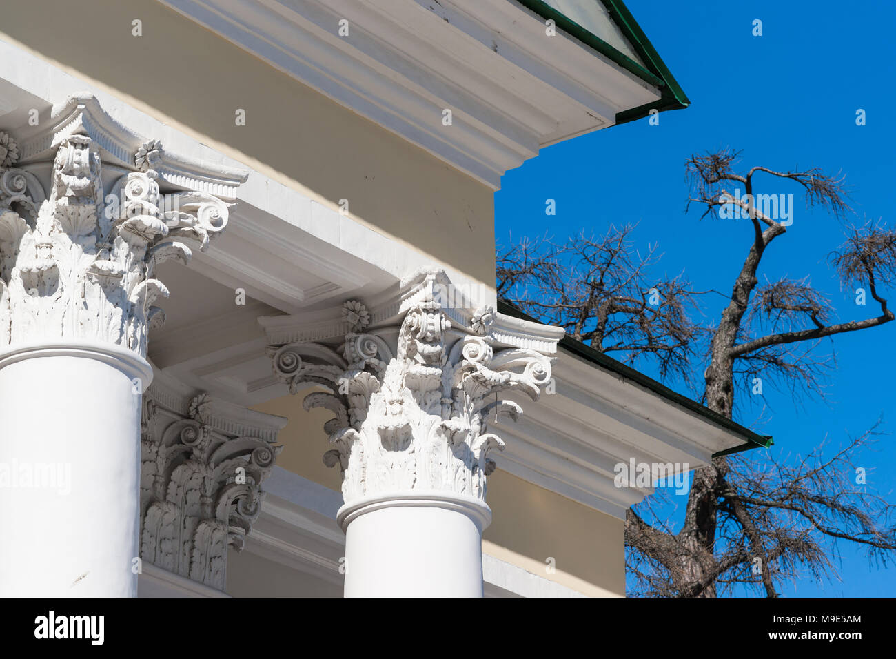 Corinthian capital of a vintage column, which supports a roof eave of a old stylish house Stock Photo