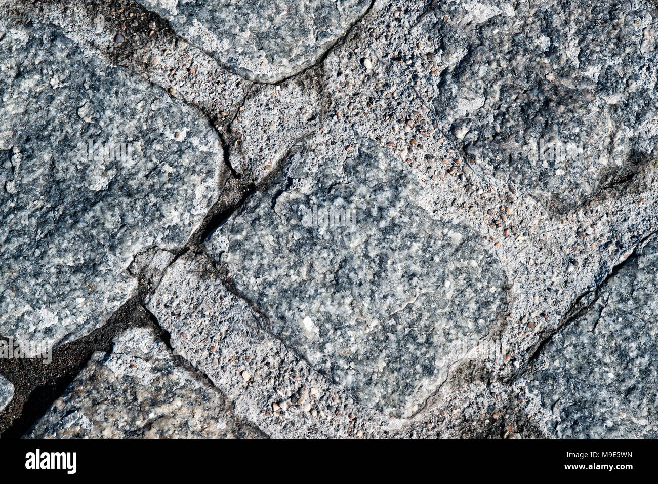 Texture of a hard rock stone paving blocks of grey and blue colors. Grunge rough surface Stock Photo