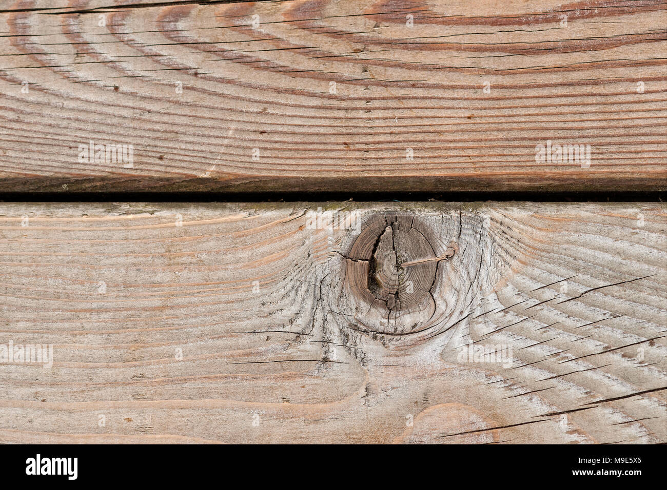 Wooden plank or board with a large knot or snag. Grey, brown, yellowish colors. Closeup view Stock Photo