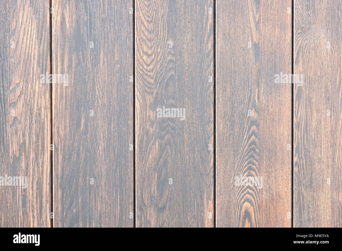 Five vertical wooden planks painted dark brown. Closeup view Stock Photo
