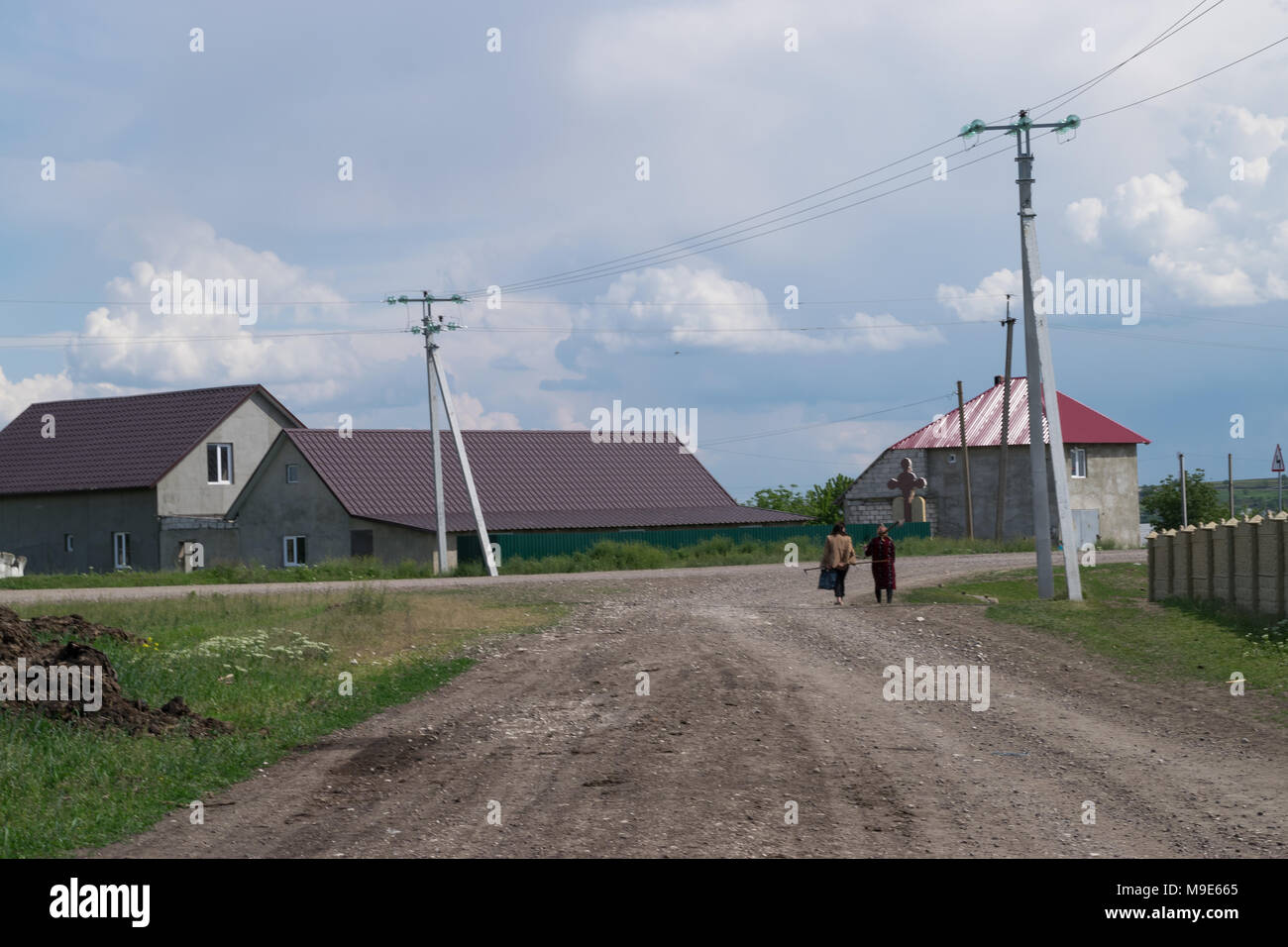 TOCUZ, MOLDOVA- 7 MAY,  2016: Two women coming after hoing their soil. Stock Photo