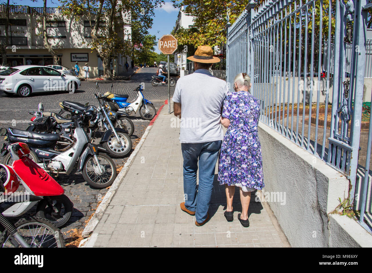 Husband helping elderly woman walk in Colonia del Sacramento, Uruguay Stock Photo
