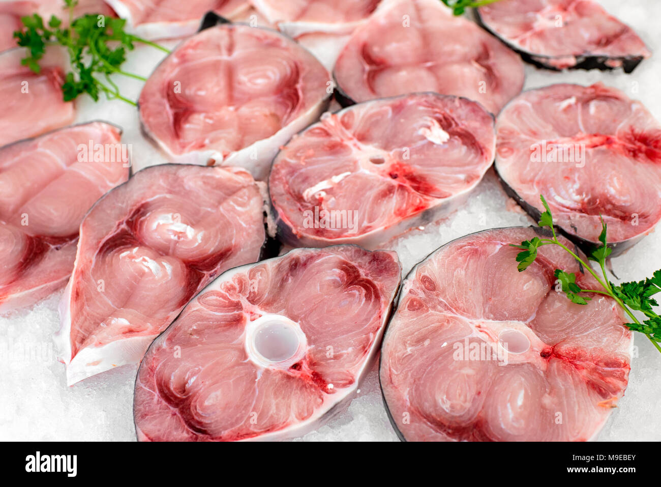 Sliced cutlets of fresh raw swordfish on display at a fish market on a bed of crushed ice for a gourmet seafood meal Stock Photo