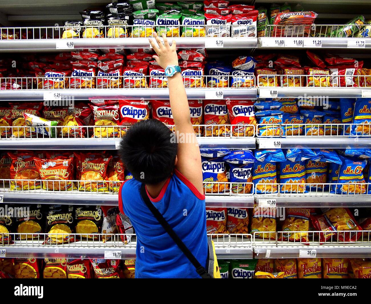 ANTIPOLO CITY, PHILIPPINES MARCH 15, 2018 A young boy reads the label of a snack food inside