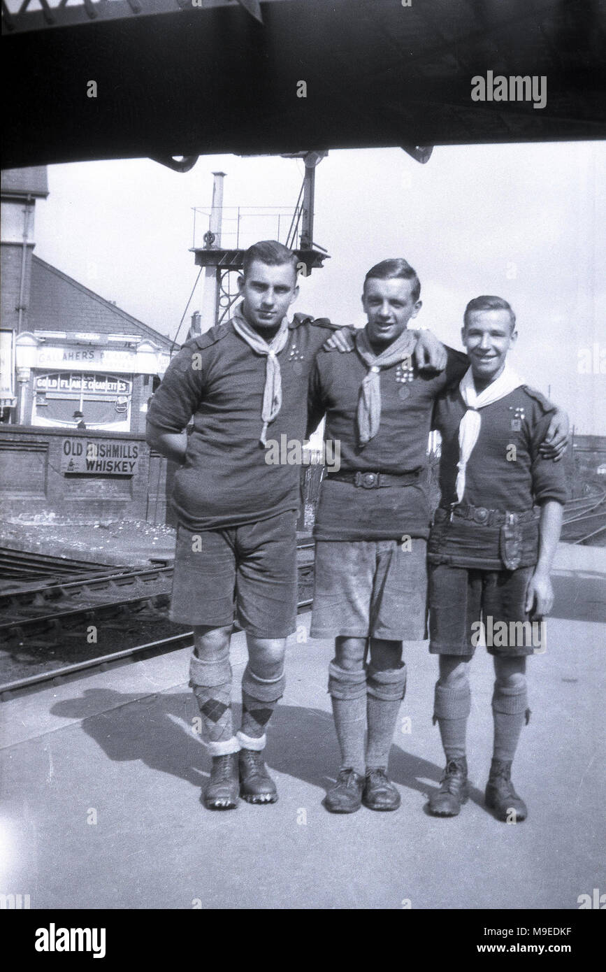 1934, historical, Dublin train station, ireland and three British scoutmasters or leaders in full uniform, pose together for a picture at the start of the overseas scouting trip. Stock Photo