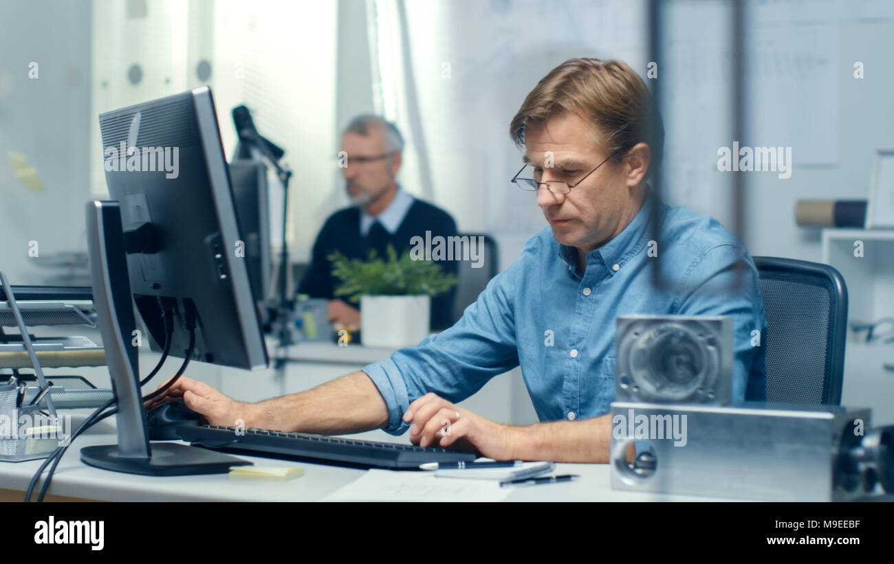 Busy Engineering Bureau. Engineer Working at His Desk, Some Technical