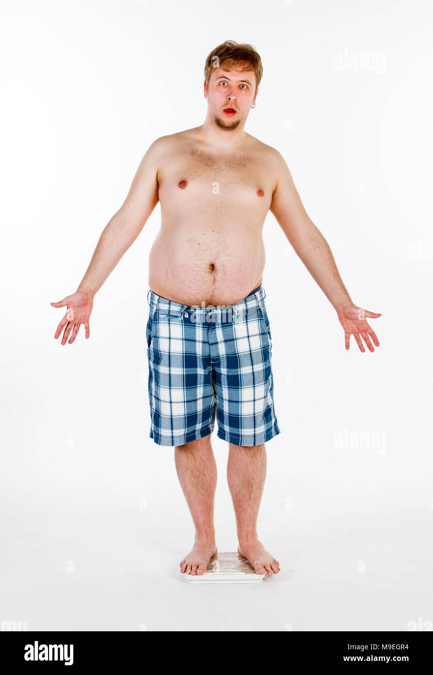 Overweight, fat man weighing himself on scales Stock Photo Alamy