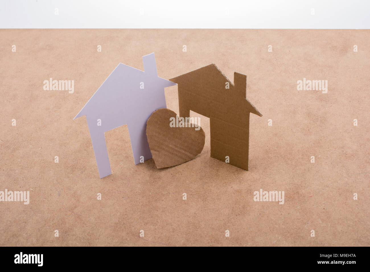 Heart shaped icon and paper houses on a brown background Stock Photo ...