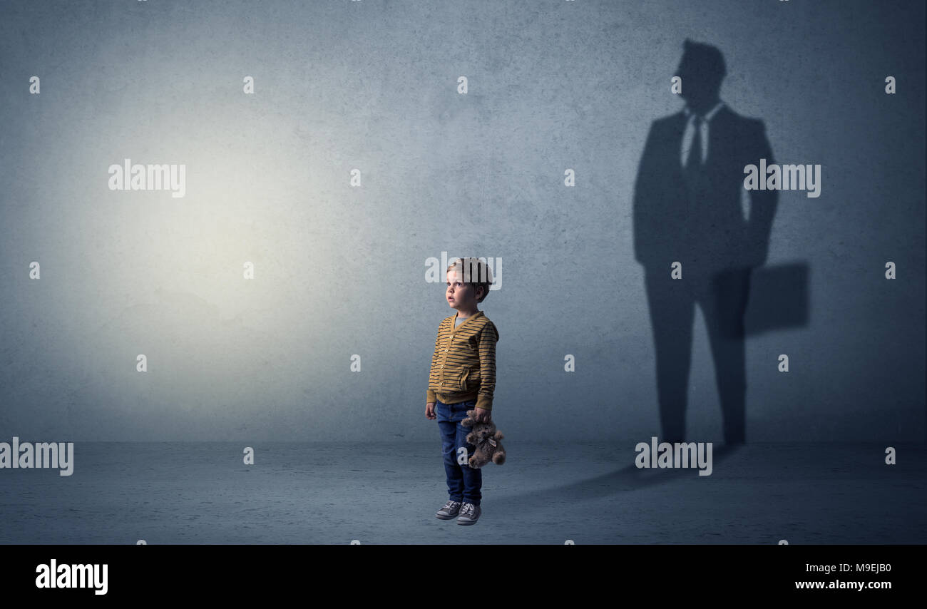Little boy imagine that he will be businessman and illustrating his future in a big shadow Stock Photo