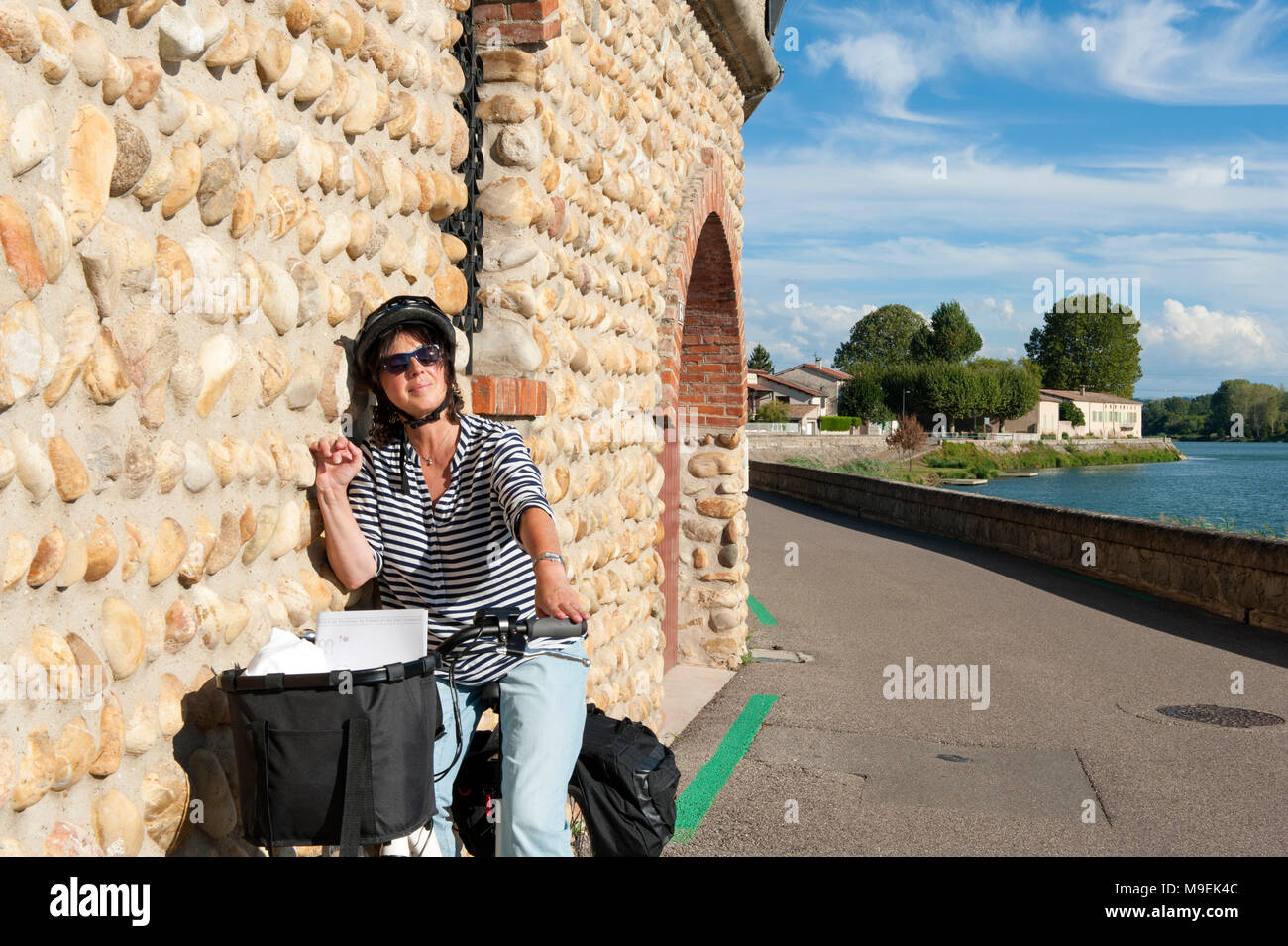 Female cyclist having a break on the ViaRhôna near Saint-Rambert d'Albon, Rhône valley, France Stock Photo