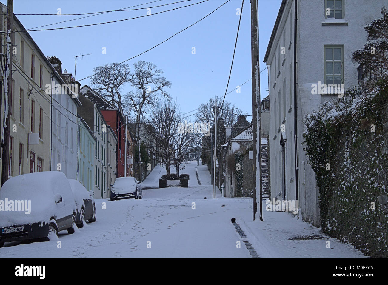 snow covered roads, sidewalk or footpaths or footpath and cars after nights snow storm. ireland Stock Photo