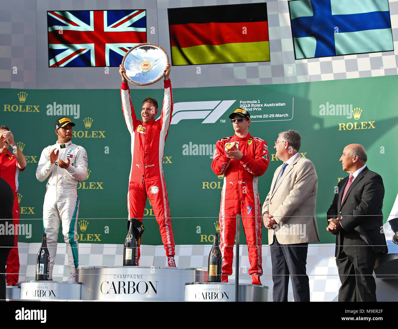 Melbourne, Australia. 25th Mar, 2018. Ferrari's Sebastian Vettel (2nd L) of  Germany celebrates with his trophy on the podium as Mercedes' Lewis Hamilton  (1st L) of Britain and Ferrari's Kimi Raikkonen (3rd