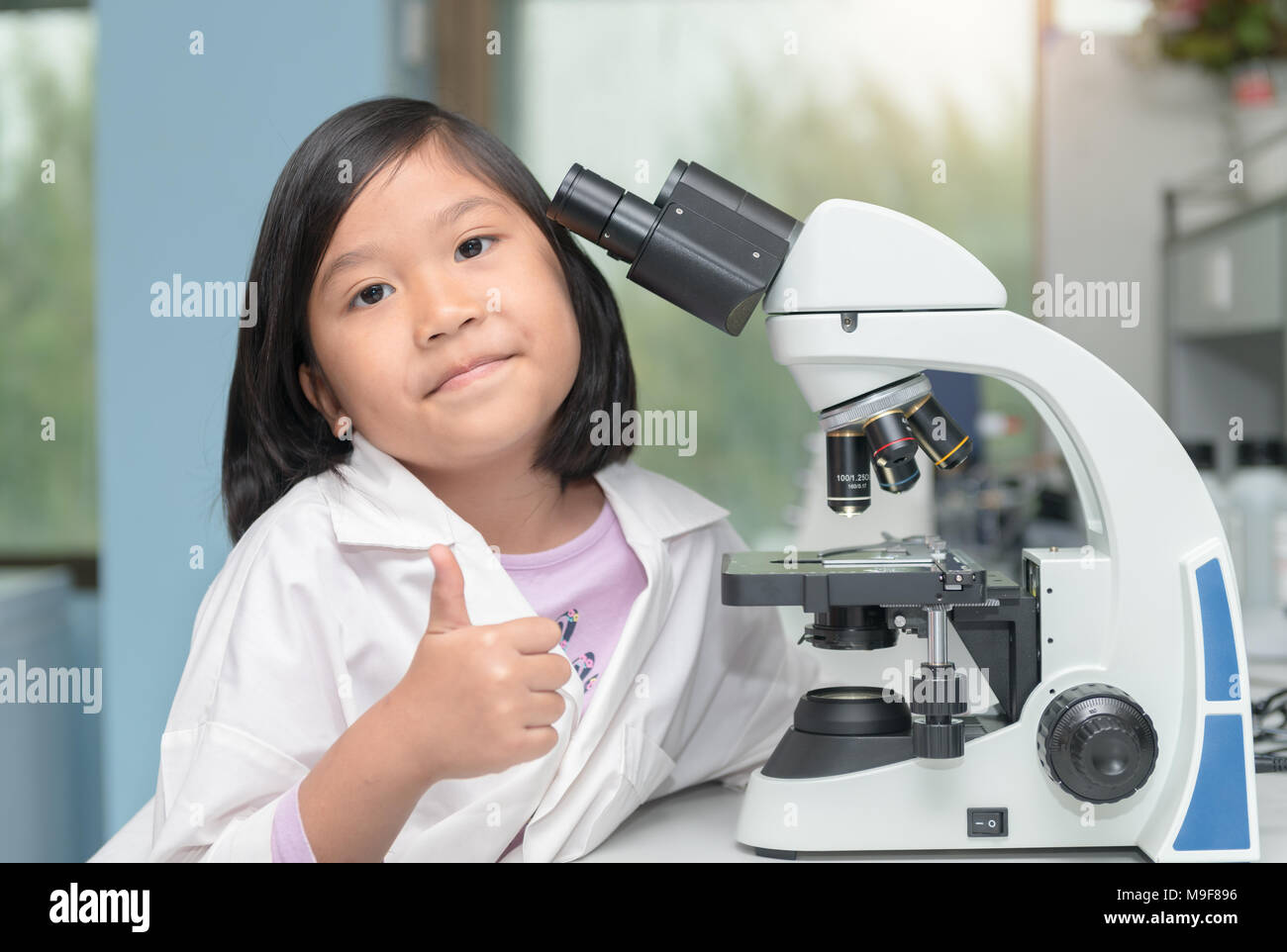 cute asian scientist girl working with microscope in laboratory, science and educaton concept Stock Photo