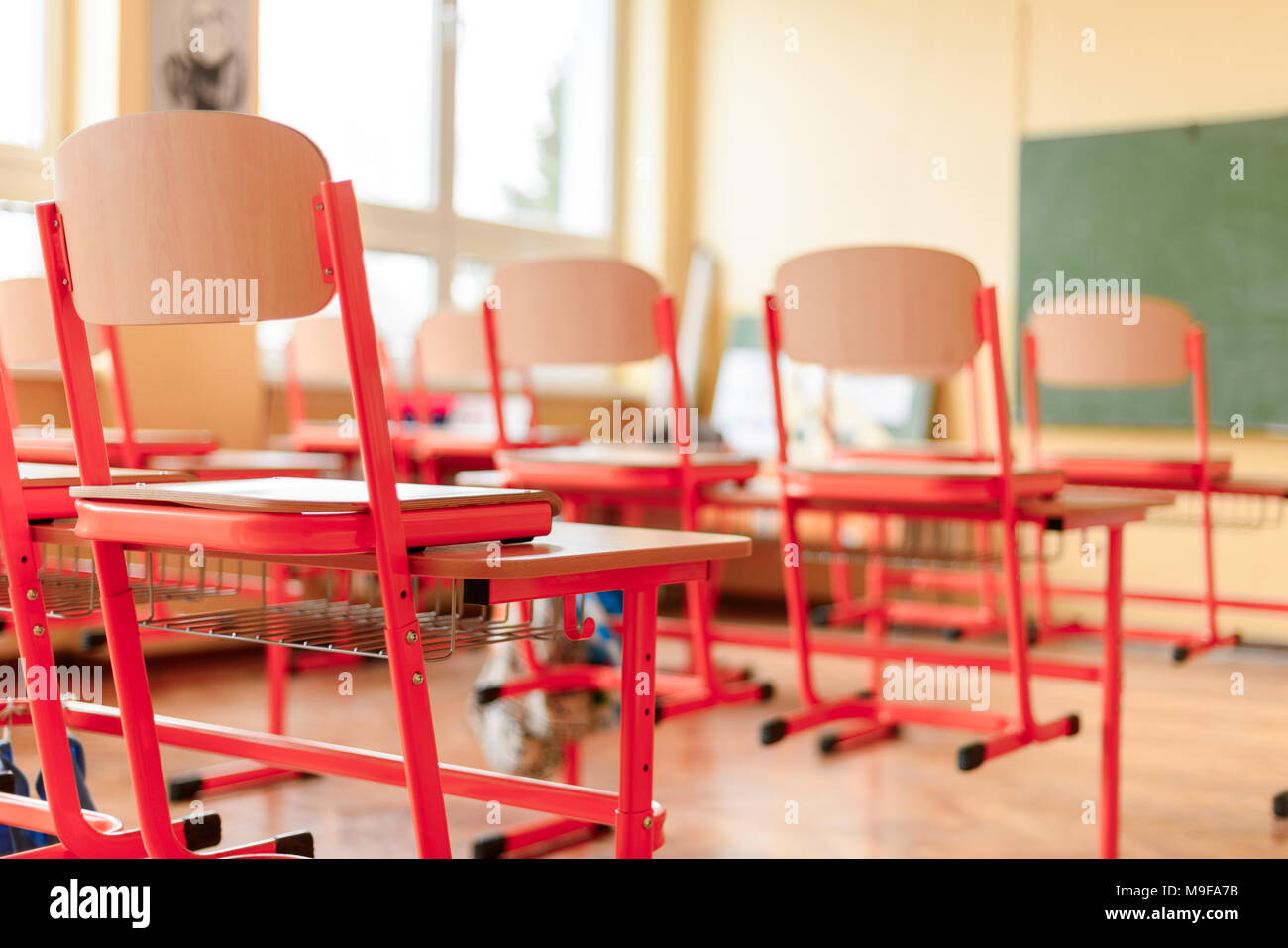 Empty classroom with school desks, chairs and blackboard. Education concept. Stock Photo