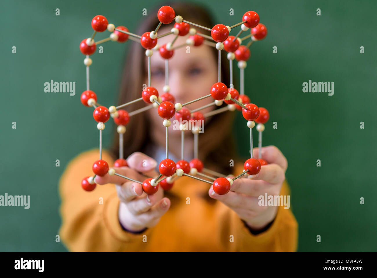 Female student holding molecular structure model. Science class concept ...