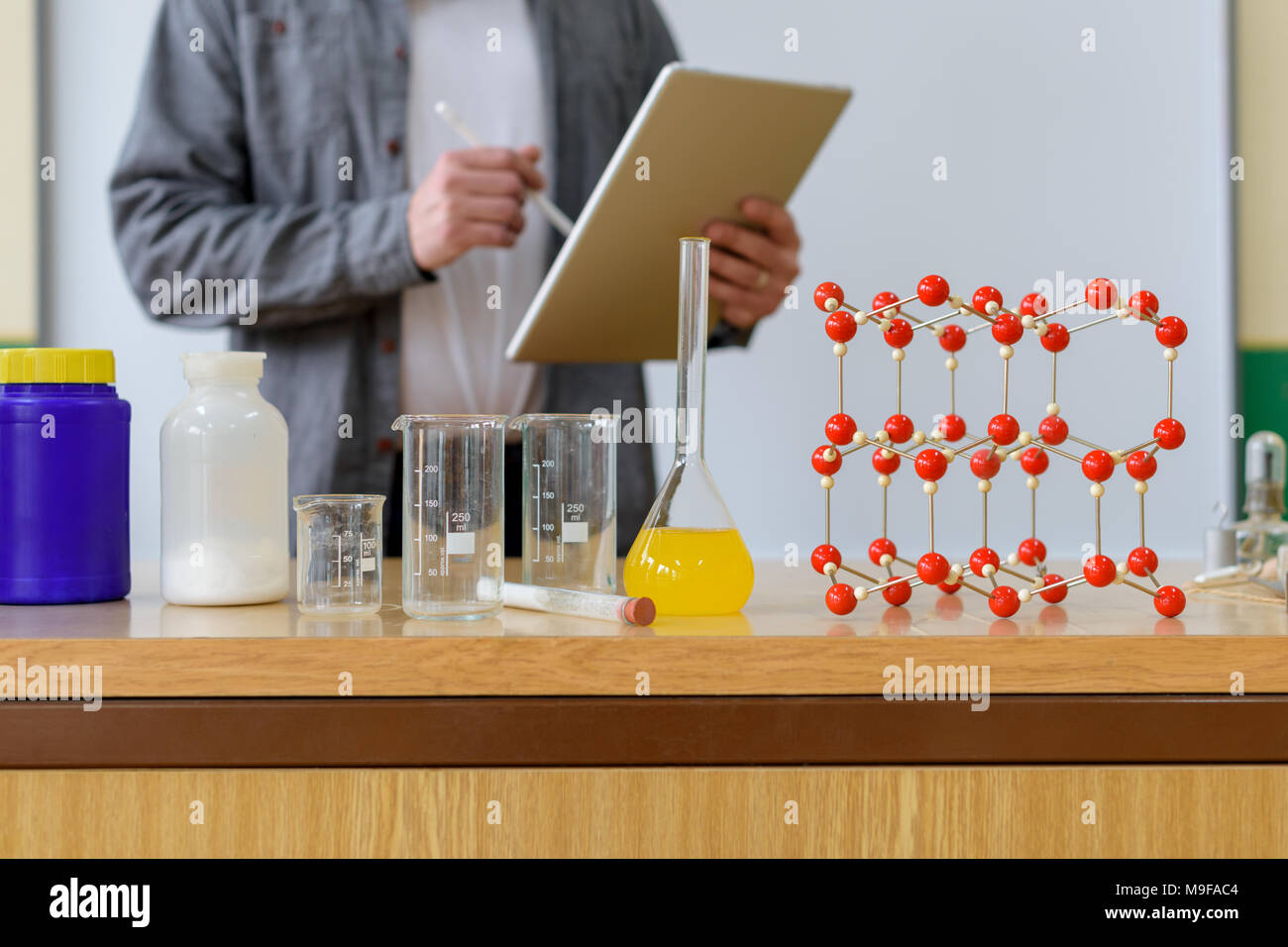 Teacher using digital tablet to teach students in chemistry class. Education, VR, Tutoring, New Technologies and Teaching Methods concept. Stock Photo