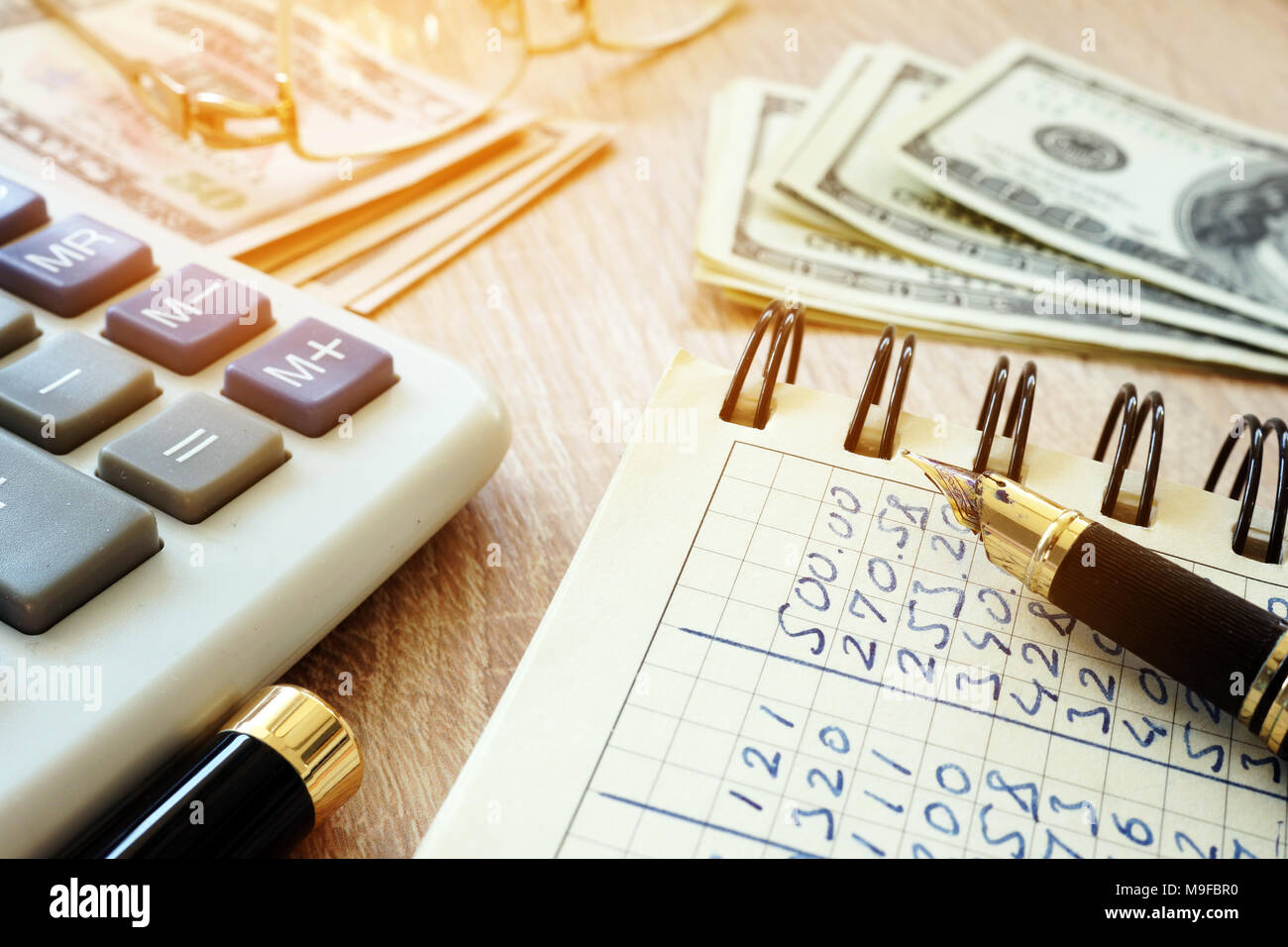 Money, calculator, pen and accounting book on a desk Stock Photo - Alamy