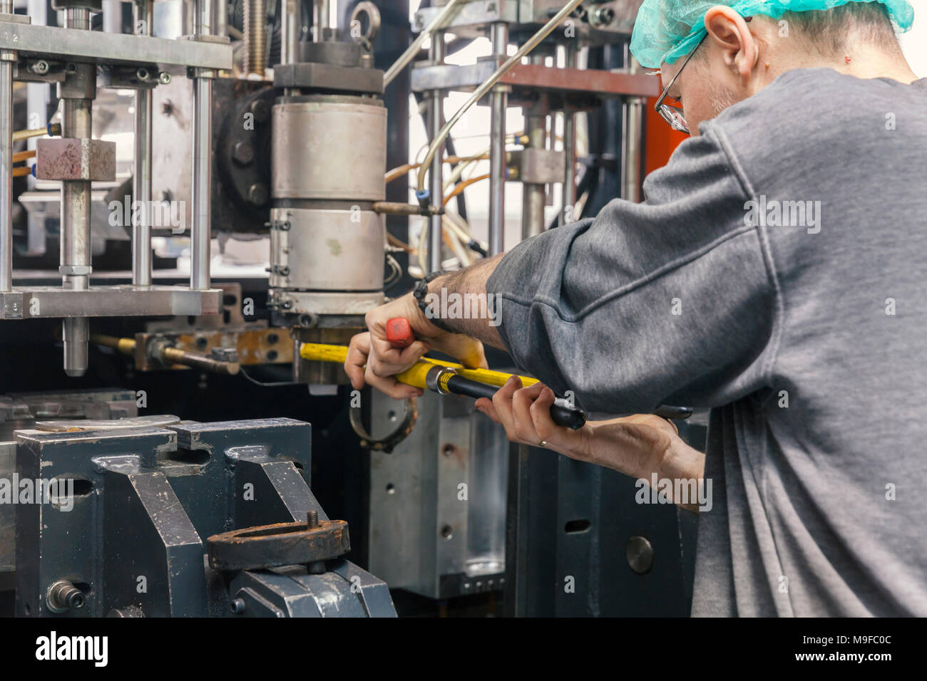 worker repairs a machine for plastic injection, close up Stock Photo ...