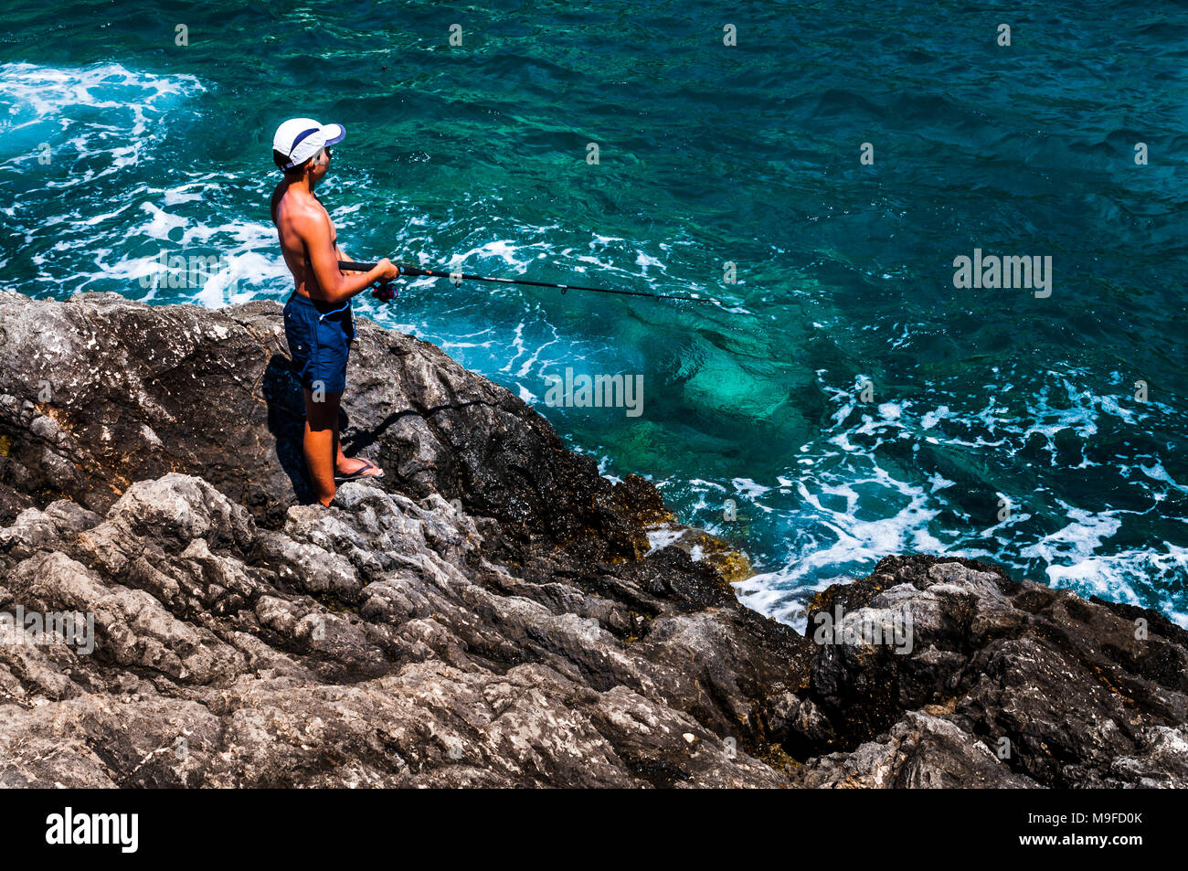 Poor young boy fishing. Poor kid risking his life for food Stock Photo ...