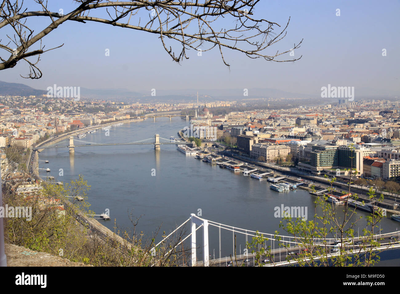 View over the rooftops and skyline of the Hungarian capital city of Budapest Hungary showing  boats  on the river Danube Stock Photo