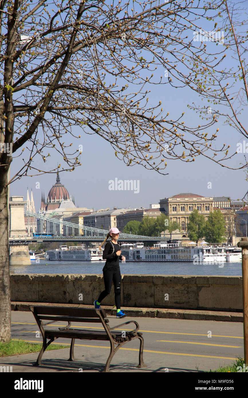 Woman running jogging to keep fit along the banks of the river Danube in the Hungarian capital city of Budapest Hungary Stock Photo